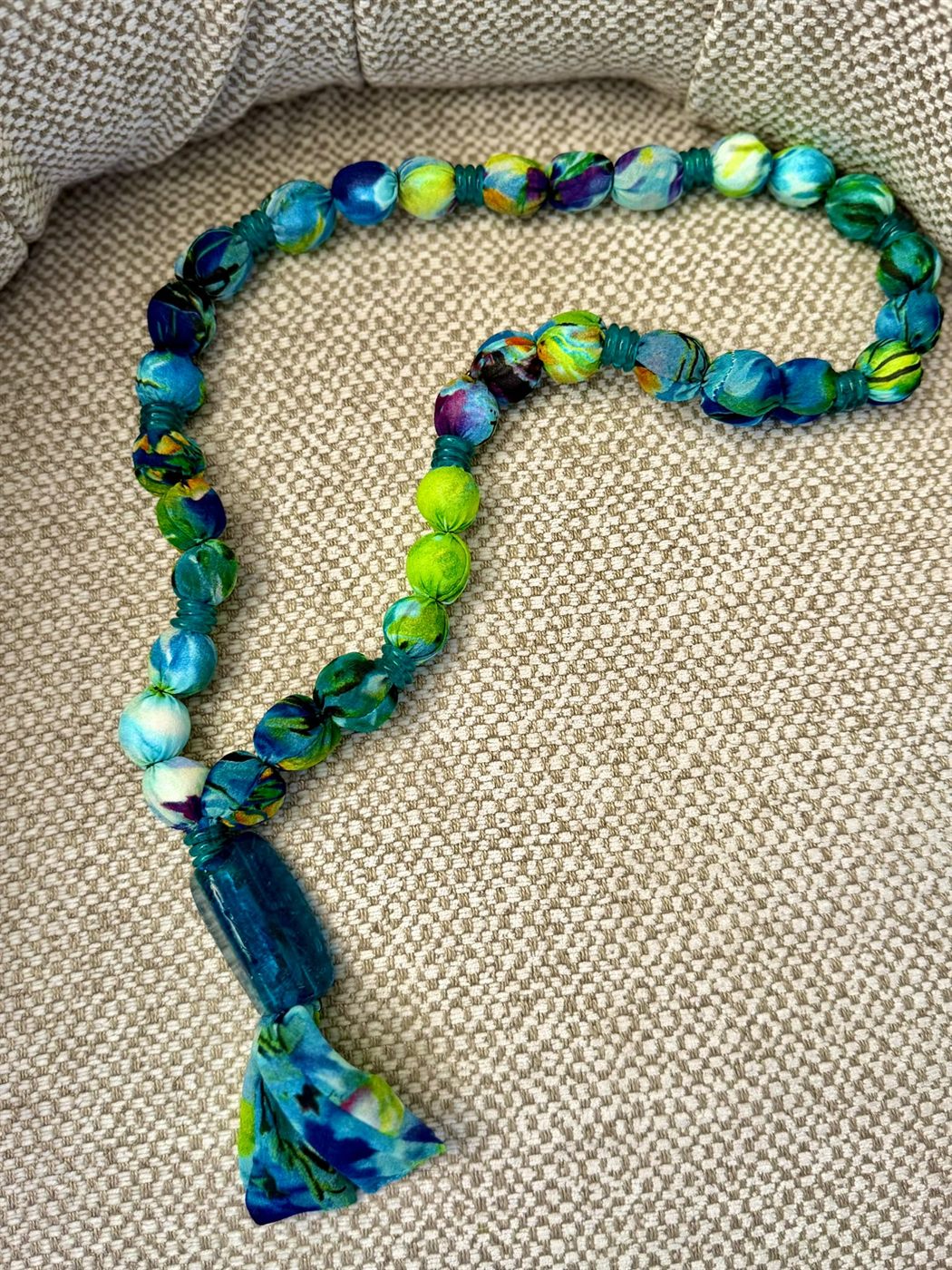 Collana Onda — Perle di stoffa verdi e blu, con nappa